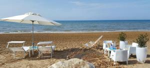 サンタ・マリア・デル・フォカッロにあるCaposud Residence and Beach Clubの海の景色を望むビーチ(椅子、パラソル付)