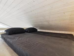 a large bed with two pillows in a room at Holiday Home Tiane - 800m from the sea by Interhome in Fanø