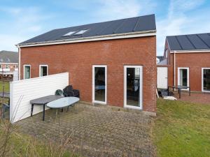Un edificio de ladrillo con una mesa y un techo solar. en Apartment Eick - 2-5km from the sea by Interhome, en Sønderby