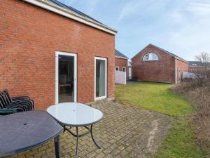 un edificio de ladrillo con una mesa y sillas en un patio en Apartment Eick - 2-5km from the sea by Interhome, en Sønderby