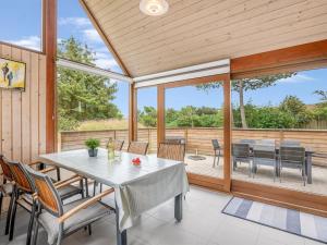 a dining room with a table and chairs on a patio at Holiday Home Martje - 900m from the sea by Interhome in Fanø