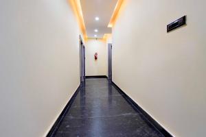 a hallway with white walls and a black tile floor at Collection O Taramandal Sahara States in Bhauvāpār
