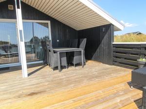 a patio with a table and chairs on a deck at Holiday Home Aska - 400m from the sea by Interhome in Fanø