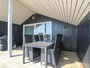 a dining room with a table and chairs on a patio at Holiday Home Aska - 400m from the sea by Interhome in Fanø