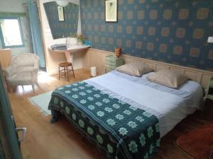 um quarto com uma cama e um lavatório em les couleurs de l'eau em Plonéour-Lanvern