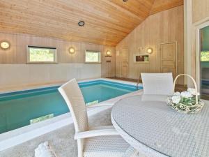 una sala con piscina, tavolo e sedie di Holiday Home Thordo - 2-4km from the sea by Interhome a Vesterhede