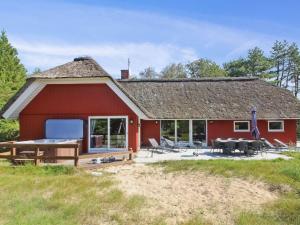 un fienile rosso con tavoli e sedie di fronte di Holiday Home Thordo - 2-4km from the sea by Interhome a Vesterhede