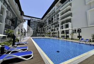 une piscine au milieu d'un immeuble dans l'établissement Bloomfields Elegance 1br in Oasis Masdar, à Abu Dhabi