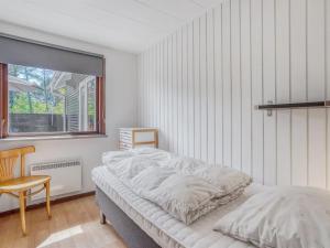 une chambre avec un lit, une chaise et une fenêtre dans l'établissement Holiday Home Halfdan - 1-1km from the sea by Interhome, à Mølby