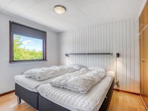 un lit dans une chambre avec une fenêtre dans l'établissement Holiday Home Halfdan - 1-1km from the sea by Interhome, à Mølby 17 autres photos