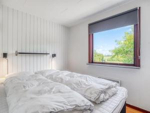 une chambre blanche avec un lit et une fenêtre dans l'établissement Holiday Home Halfdan - 1-1km from the sea by Interhome, à Mølby