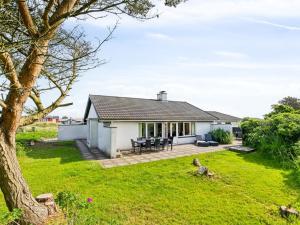 a white cottage with a large grass yard at Holiday Home Kita - 500m from the sea by Interhome in Lakolk