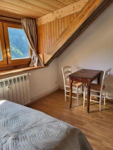 a bedroom with a table and chairs and a bed at Gîte à Molines en Queyras 8-15 pers in Molines-en-Queyras