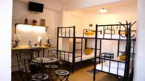 a room with four bunk beds and a table at Taxi Hostel in Otopeni