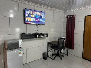 a room with a desk and a television on a wall at Tsekida Guest Lodge in Manamakgoteng