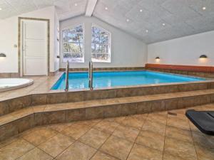 una grande piscina in un bagno con vasca e lavandino di Holiday Home Nael - 1-6km from the sea by Interhome a Mølby