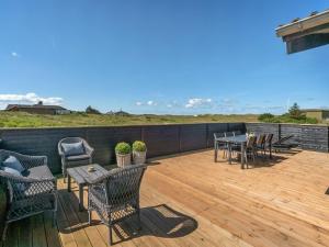 a patio with tables and chairs on a wooden deck at Holiday Home Ortwin - 300m from the sea by Interhome in Lakolk