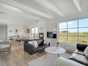 a living room with a couch and a table at Holiday Home Ortwin - 300m from the sea by Interhome in Lakolk