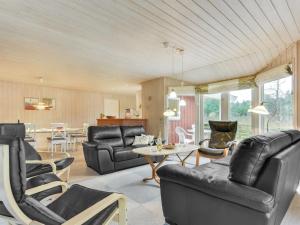 - un salon doté d'un mobilier en cuir noir et d'une table dans l'établissement Holiday Home Harthwik - 1km from the sea by Interhome, à Mølby