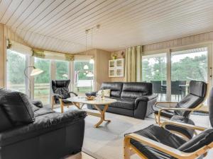 - un salon doté d'un mobilier en cuir noir et d'une table dans l'établissement Holiday Home Harthwik - 1km from the sea by Interhome, à Mølby