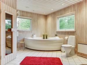La grande salle de bains est pourvue d'une baignoire et de toilettes. dans l'établissement Holiday Home Harthwik - 1km from the sea by Interhome, à Mølby 14 autres photos