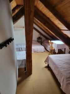 a attic room with two beds and a table at Gîte à Molines en Queyras 8-15 pers in Molines-en-Queyras