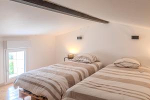 two beds in a white room with a window at Gite Berclois in Bercloux