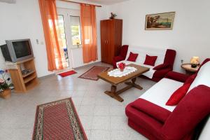 sala de estar con sofá rojo y mesa en Apartments Jasmin, en Trogir