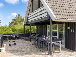 a patio with a grill and a table and chairs at Holiday Home Sunita - 2-8km from the sea by Interhome in Toftum