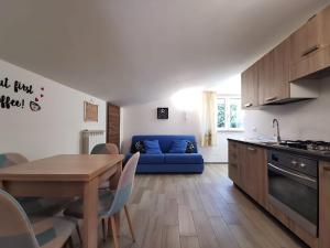 a kitchen and living room with a blue couch and a table at Peter's apartment - Moto & Bike Parking in Castel SantʼElia
