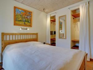 a bedroom with a white bed and a painting on the wall at Holiday Home Siegried - 2-2km from the sea by Interhome in Vesterhede