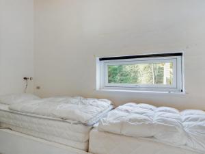 une chambre avec deux lits blancs et une fenêtre dans l'établissement Holiday Home Reinbald - 1km from the sea by Interhome, à Mølby