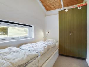 un grand lit dans une chambre avec une fenêtre dans l'établissement Holiday Home Reinbald - 1km from the sea by Interhome, à Mølby
