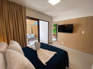a bedroom with a bed with pillows and a window at Condomínio Villa Morro in Cayru