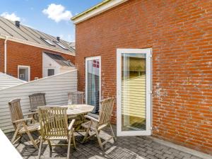 eine Terrasse mit einem Tisch und Stühlen neben einem Backsteingebäude in der Unterkunft Apartment Nils - 2-3km from the sea by Interhome in Sønderby