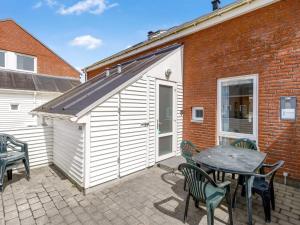 ein Gebäude mit einem Tisch und Stühlen und einem Tisch in der Unterkunft Apartment Nils - 2-3km from the sea by Interhome in Sønderby