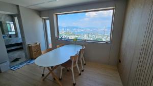 a table and chairs in a room with a large window at Youngdo Blue Sky 