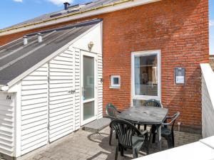 eine Terrasse mit einem Tisch und Stühlen neben einem Gebäude in der Unterkunft Apartment Nils - 2-3km from the sea by Interhome in Sønderby