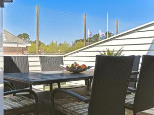 una mesa con sillas y un bol de fruta en el patio en Apartment Gaëlle - 2-3km from the sea by Interhome, en Sønderby