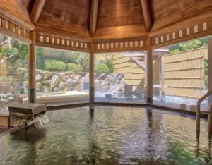 a large swimming pool in a house with a large window at B&B Sampark in Shirahama
