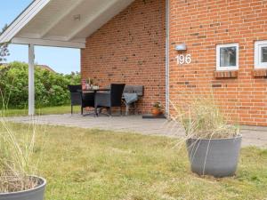 a patio with a table and chairs on a brick building at Holiday Home Solina - 500m from the sea by Interhome in Lakolk +27 photos