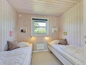 two beds in a room with a window at Holiday Home Chrisse - 550m from the sea by Interhome in Lakolk