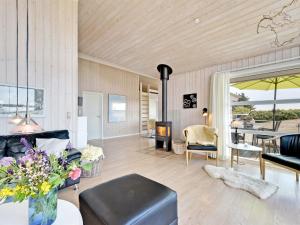 a living room with a couch and a fireplace at Holiday Home Chrisse - 550m from the sea by Interhome in Lakolk