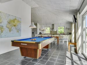 a pool table in a room with a kitchen at Holiday Home Svanborg - 3-7km from the sea by Interhome in Rømø Kirkeby