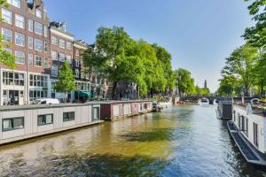 einen Kanal in einer Stadt mit Gebäuden und einer Brücke in der Unterkunft Mercedes Bed&Breakfast Amsterdam in Amsterdam