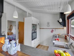 una cucina con armadi bianchi e un bancone con lavandino di Holiday Home Arjuna - 3-8km from the sea by Interhome a Tagholm