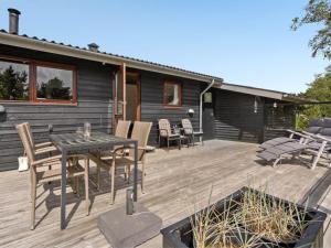 eine Terrasse mit einem Tisch und Stühlen auf einem Haus in der Unterkunft Holiday Home Arjuna - 3-8km from the sea by Interhome in Tagholm