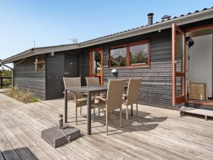 ein Haus mit einem Tisch und Stühlen auf einer Terrasse in der Unterkunft Holiday Home Arjuna - 3-8km from the sea by Interhome in Tagholm