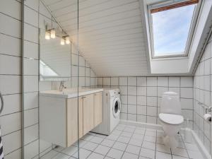 ein Badezimmer mit Toilette, Waschbecken und Waschmaschine in der Unterkunft Apartment Ameli - 2-3km from the sea by Interhome in Sønderby