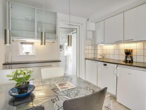 eine Küche mit Glastisch und weißen Schränken in der Unterkunft Apartment Ameli - 2-3km from the sea by Interhome in Sønderby